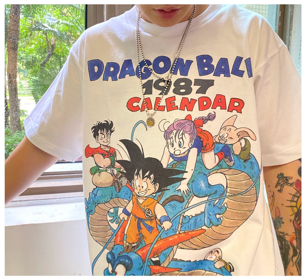 Vintage 1987 Dragon Ball Z Calendar T-Shirt Black Anime Graphic Tee Retro Manga-Inspired Apparel Stylish Casual Outfit Collectible Fan Merchandise Classic DBZ Design Nostalgic Streetwear